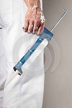 Workman Hand holding Caulking Gun for Silicone Sealant photo