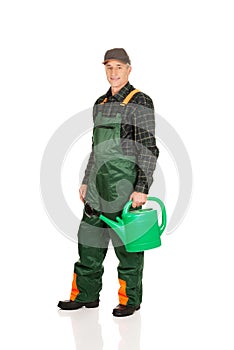 Workman holding green watering can