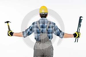 Workman holding hammer and pipe wrench