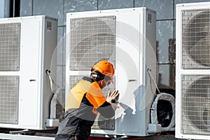 Workman installing outdoor unit of the air conditioner