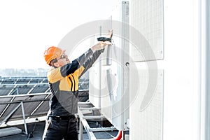 Workman installing outdoor unit of the air conditioner