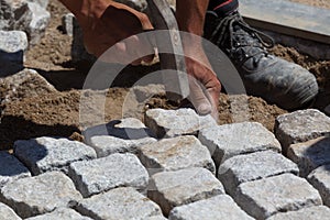 Workman laying cobbles