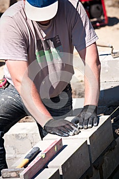 Workman laying concrete blocks