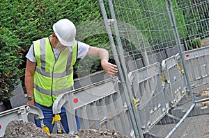 Workman looking down at Fence