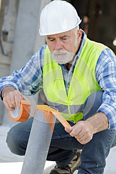 workman measuring pipe