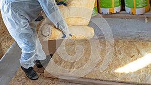 Workman in overalls working with rockwool insulation material