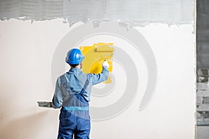 Workman painting wall indoors