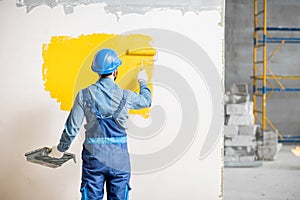 Workman painting wall indoors