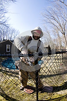 Workman repairing building chain link fence