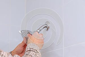 Workman repairing shower head in bathroom