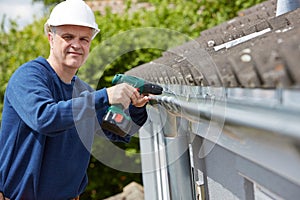 Workman Replacing Guttering On Exterior Of House