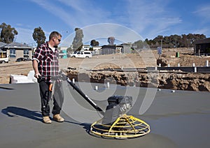 Workman smoothing newly poured concrete photo