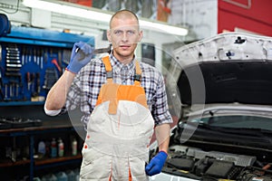 Workman standing near car at auto repair