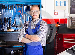 Workman standing near car at auto repair