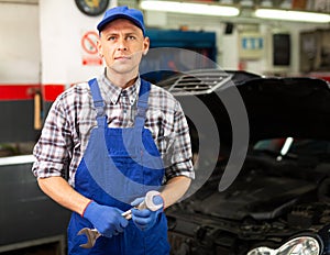 Workman standing near car at auto repair