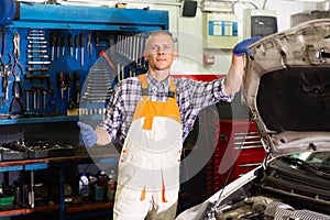 Workman standing near car at auto repair