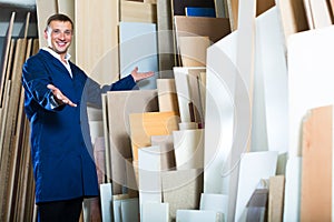 Workman standing with plywood pieces