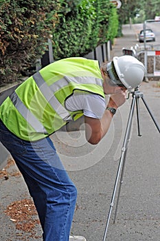 Workman surveying road