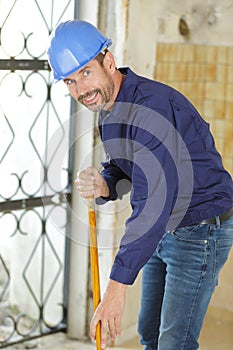 workman sweeping floor