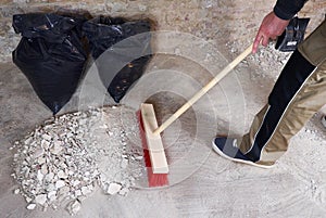 Workman sweeping the rubble with broom