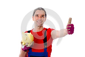 Workman with thumb up is showing a piggy bank