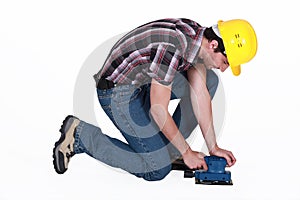 Workman using an electric sander