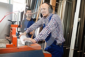 Workmen near cutter - lathe machine at factory v