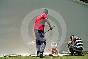 Workmen painting wall