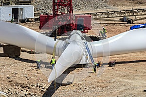 Workmen prepare a large rotor assembly for wind turbine