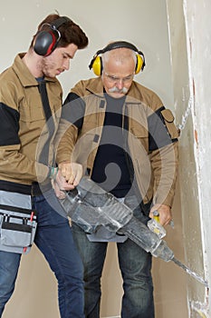 Workmen using hammer drill