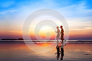 Workout background, two people jogging on the beach