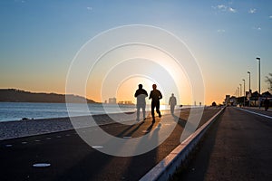 Workout background, two people jogging on the waterfront at sunset, runners silhouettes, healthy lifestyle concept