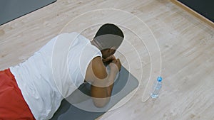 Workout. Black sport man doing plank exercise for tights at gym. Male athlete exercising on yoga mat, planking and