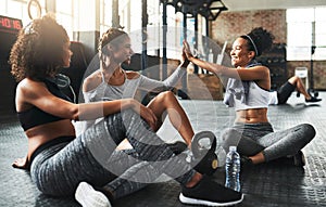 Workout buddies keep you motivated. young women giving each other a high five while taking a break at the gym.