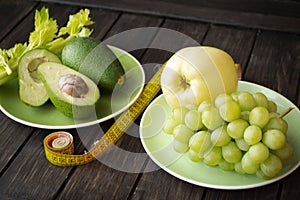 Workout and fitness dieting concept. Healthy lifestyle wth green color fruits and vegetables. With tape measure