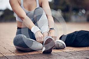 Workout, fitness and woman tying shoes on feet, sitting on ground before marathon training or running. Health, wellness