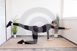 Workout at home.Athletic woman in sportswear doing stretching exercises at home in the living room.