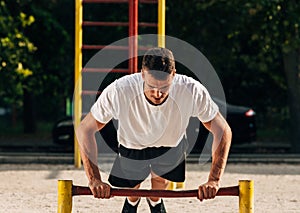 Push ups or press ups exercise by young man while working out on grass crossfit strength training