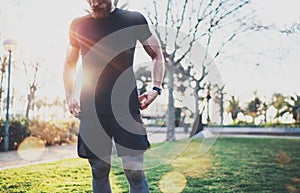 Workout lifestyle concept.Young man preparing muscles before training.Muscular athlete exercising outside in sunny park