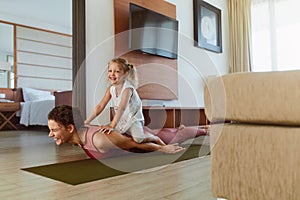 Workout. Mother And Daughter Exercising Together At Home. Happy Young Woman And Child Having Fun In Living Room.