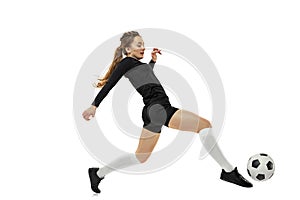 Workout. One sportive girl, female soccer player practicing with football ball isolated on white studio background