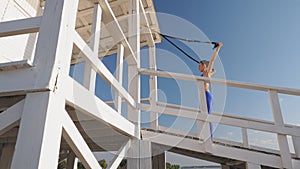 workout outdoors. suspension straps. workout with straps. Athletic young woman is doing all-body resistance exercises