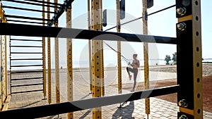 workout outdoors. suspension straps. workout with straps. Athletic young woman is doing all-body resistance exercises