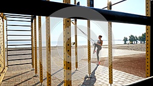 workout outdoors. suspension straps. workout with straps. Athletic young woman is doing all-body resistance exercises