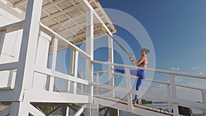 workout outdoors. suspension straps. workout with straps. Athletic young woman is doing all-body resistance exercises