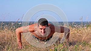 Workout. Pushups Fitness Man doing Push-ups Outside on Nature.