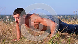 Workout. pushups fitness man doing push-ups outside on nature.