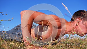 Workout. Pushups fitness man doing push-ups outside on nature. Slow motion