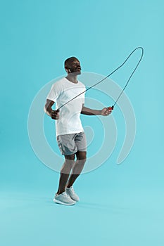 Workout. Sports man in sportswear exercising on jumping rope