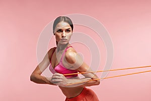 Workout. Woman Training With Resistance Bands On Pink Background